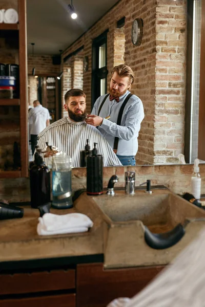 Barber Cutting Man's Beard In Barber Shop. Hairdresser Doing Beard Hair Cut With Scissors And Comb In Men Beauty Salon. High Resolution