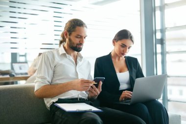 İş adamları modern ofisinde çalışıyor. Bilgisayar, cep telefonu kullanan adam çalışan kadın. Yüksek çözünürlük