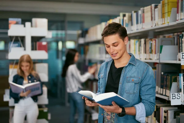 Estudante Leitura Universitária Livro Biblioteca Homem Com Livros Perto Estantes — Fotografia de Stock