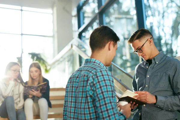 Estudiantes Aprendiendo Leyendo Libro Universidad Jóvenes Discutiendo Notas Cuaderno Pie — Foto de Stock