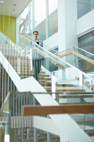 Female Worker On Stairs In Office Indoors. Business Woman In Modern Office Building. High Resolution