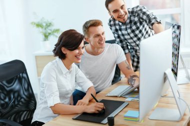 Takım insanların bilgisayarda Office çalışma. Mutlu gülümseyen işçilerin proje üzerinde birlikte çalışma. Yüksek çözünürlük