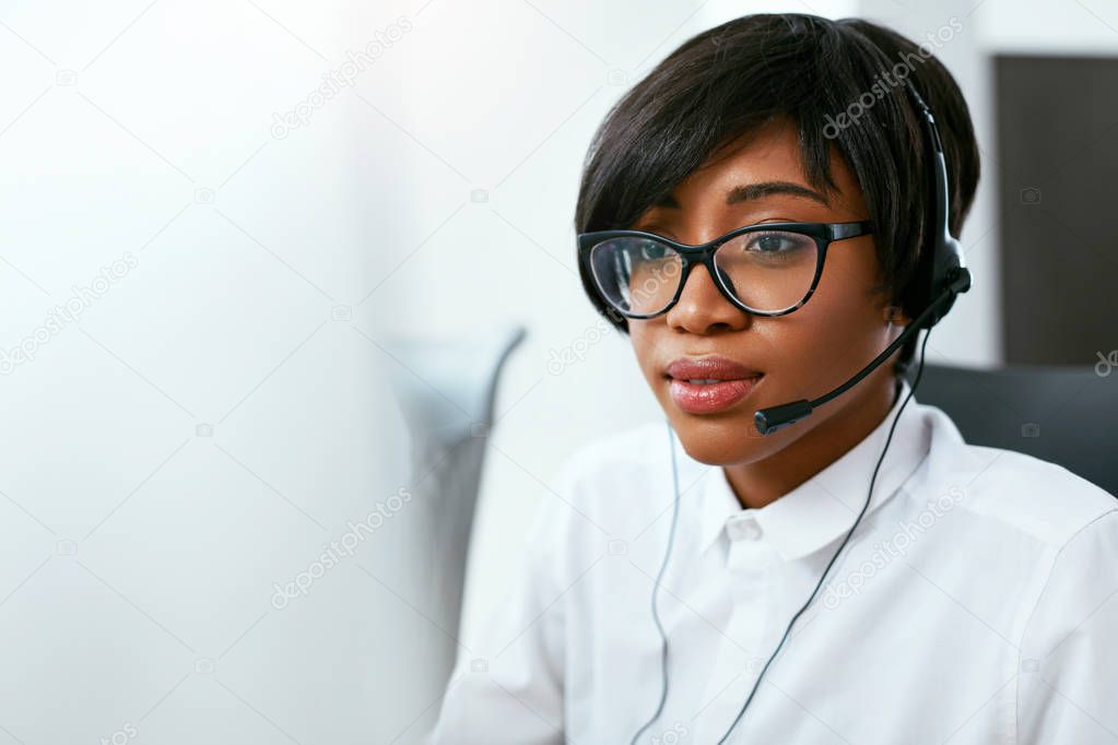 Call Center Agent Working On Hotline. Attractive Afro-American Woman Serving Customers In Contact Center. High Resolution