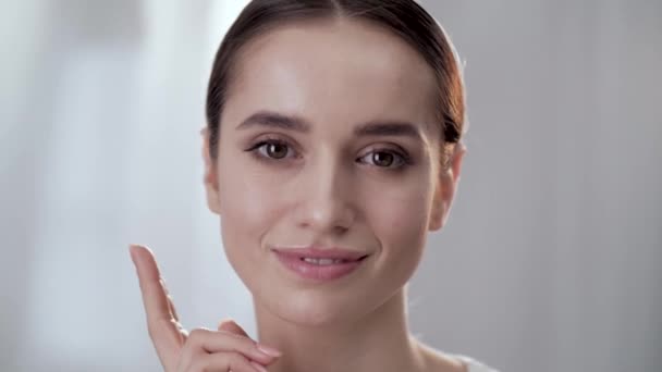 Zdrowa skóra. Piękna kobieta stukanie przez palce na twarz — Wideo stockowe