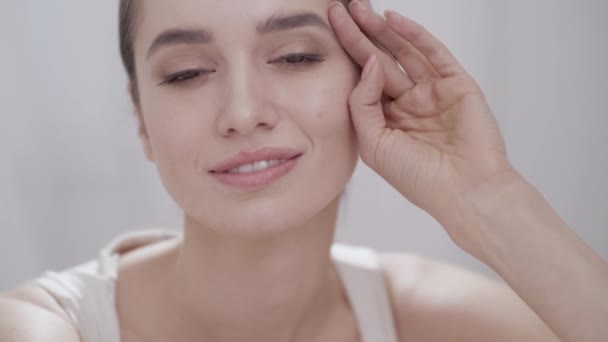 Schönheit Gesicht Nahaufnahme. Frau berührt Haut und lächelt — Stockvideo