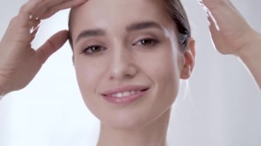 Güzellik yüz portre. Kadın cilt dokunmak ve gülümseyen