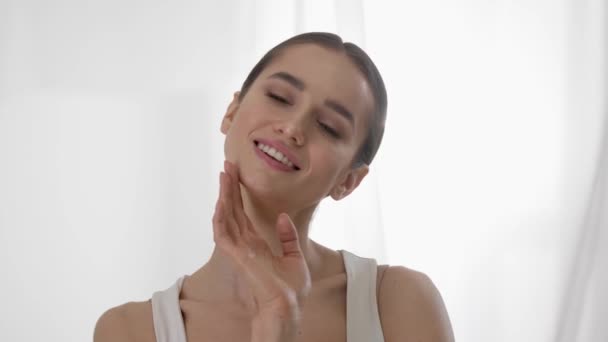 Kosmetikpflege. Frau mit gesunder Haut berührt Gesicht und lächelt — Stockvideo