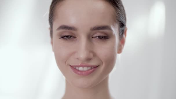 Cuidado facial de las mujeres. Sonriente mujer tocando la piel en la cara — Vídeo de stock