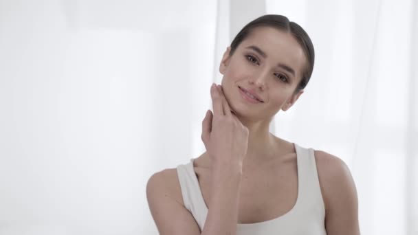 Mujer Belleza. Retrato Hermosa sonrisa chica tocando la piel de la cara — Vídeos de Stock