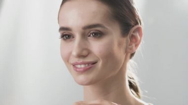 Cilt Bakımı. Yüz parmaklarıyla dokunarak gülümseyen güzel kadın 