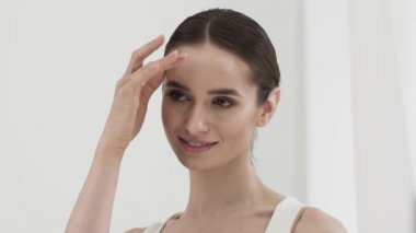 Güzellik bakımı. Çekici gülümseyen kadın yüz cildi okşama 