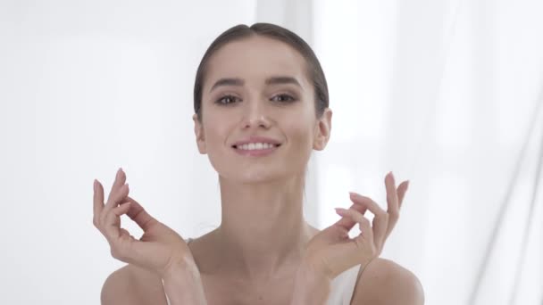 Kosmetikpflege. Frau mit gesunder Haut berührt Gesicht und lächelt — Stockvideo