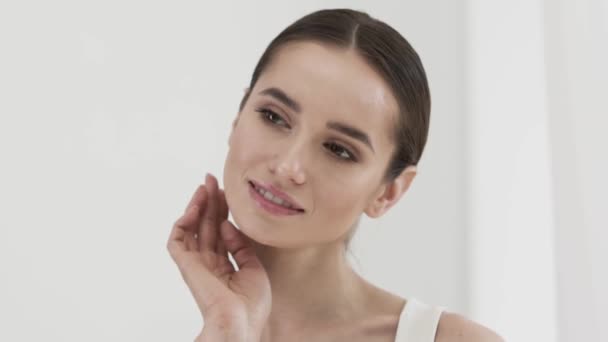 Schoonheidsverzorging. Aantrekkelijke lachende vrouw gezicht huid strelen — Stockvideo