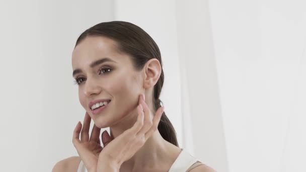Skönhetsvård. Attraktivt leende kvinna smeka ansiktet huden — Stockvideo