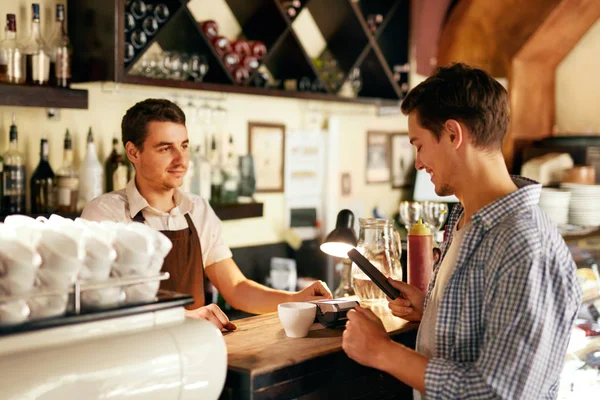 Cliente che paga con il telefono cellulare nel caffè — Foto Stock