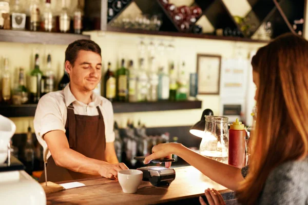 Cliente che paga con il telefono cellulare nel caffè — Foto Stock