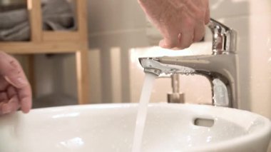 Banyo lavabo içinde akan suyun üzerinde eller dönüş yakın çekim