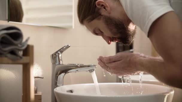 Ranní hygiena. Muž mytí obličeje s čistou vodou v koupelně — Stock video