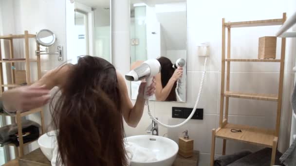 Cuidado del cabello. Mujer secado pelo largo con secador de pelo en el baño — Vídeos de Stock