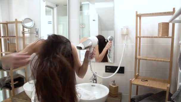 Cuidado del cabello. Mujer secado pelo largo con secador de pelo en el baño — Vídeo de stock