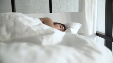 Mutlu kadın up beyaz keten ile rahat yatakta uyanma