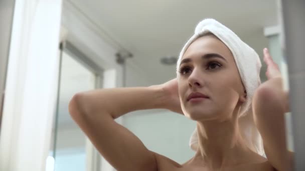Hermosa mujer después de ducha mirando en espejo en cuarto de baño — Vídeos de Stock