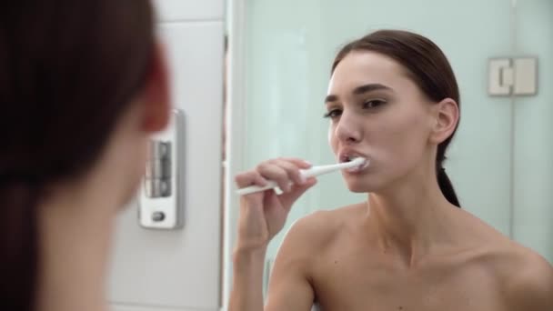 Tandhälsa. Kvinna borsta tänderna i badrum — Stockvideo