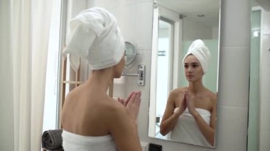 Yüz bakımı. Tuvalette Cilde Krem Süren Kadın