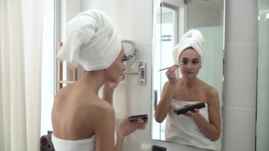 Makyaj. Kadın kaptırdın uygulamak ve aynaya bakıyor