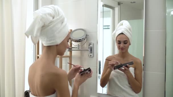 Make-upu. Žena použití Eyeshadows a při pohledu na zrcadlo — Stock video