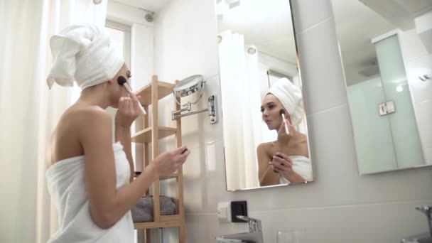 Make-upu. Žena aplikaci pudru na obličej kůži v koupelně — Stock video
