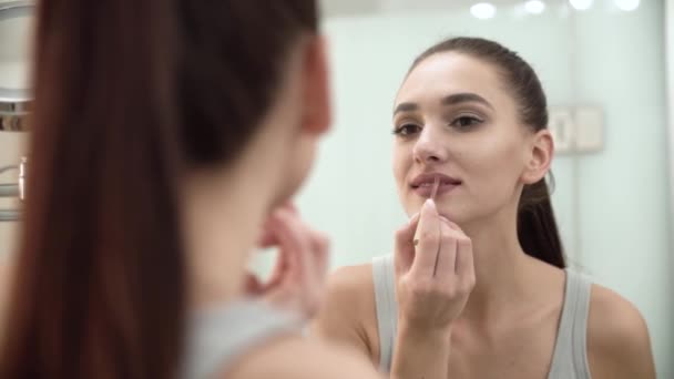 Maquillage. Femme appliquant du rouge à lèvres liquide sur les lèvres à la salle de bain — Video