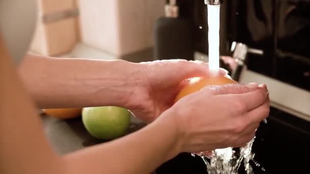 Миття фруктів чистою водою на кухні крупним планом — стокове відео
