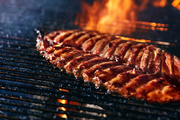 Pork Ribs Cooking On Grill Closeup. Cooking Grilling Meat On Fire. High Resolution 