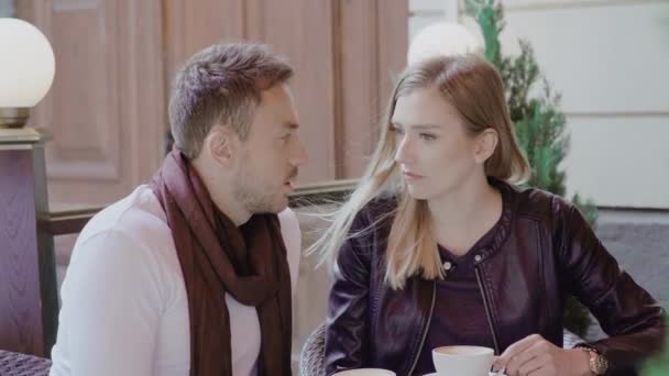 Пара п'є каву на побачення в кафе на відкритому повітрі — стокове відео