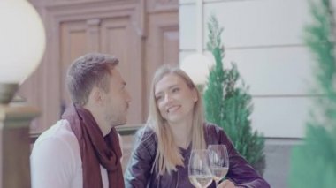 Bir çift şarap içiyor ve birlikte restoranda eğleniyor.