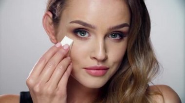 Güzellik makyajı. Süngerle Yüze Kozmetik Uygulayan Kadın