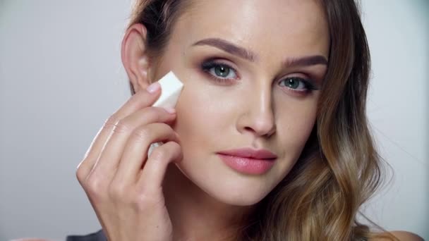 Maquiagem de beleza. Mulher aplicando cosméticos faciais com esponja — Vídeo de Stock