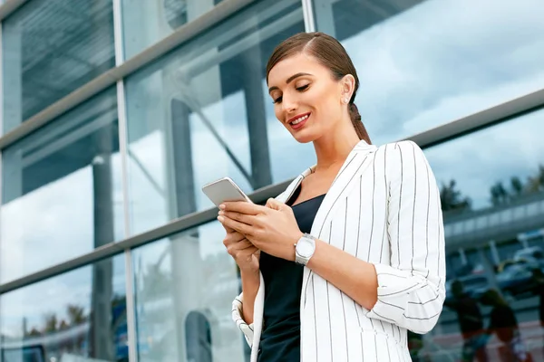 Donna d'affari utilizzando il telefono vicino all'ufficio — Foto Stock