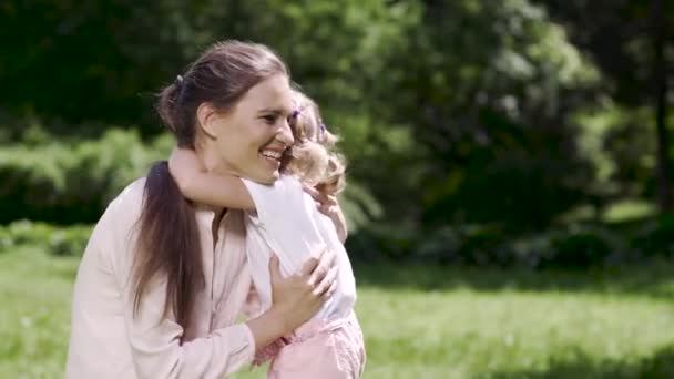 Счастливая семья. Женщина и ребенок обнимаются и целуются в природе — стоковое видео