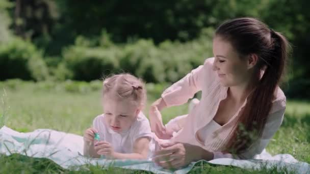 Mãe e filho se divertindo na grama no parque — Vídeo de Stock