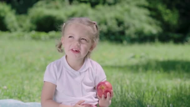 Une nutrition saine. Enfant mangeant des pommes juteuses à l'extérieur