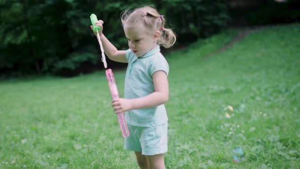 Kind heeft plezier in de natuur. Meisje maken zeepbellen buiten — Stockvideo