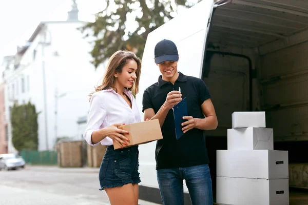 Serviço de entrega. Courier entrega pacote para mulher perto do carro — Fotografia de Stock