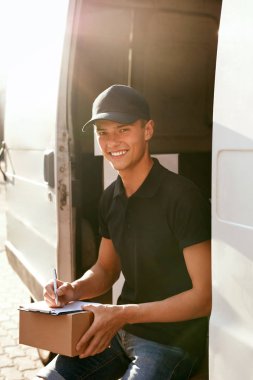 Kurye teslim Servisi. Adam araç açık havada yakınındaki kutusuyla