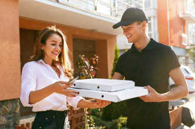 Pizza teslimatı. Kurye gıda açık havada kutularıyla kadın vererek. Müşteri sipariş alma. Yüksek çözünürlük