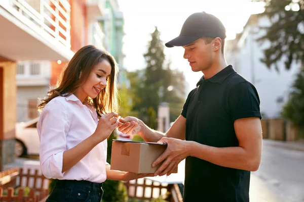 Corriere consegna pacchetto a donna, documento di firma del cliente — Foto Stock