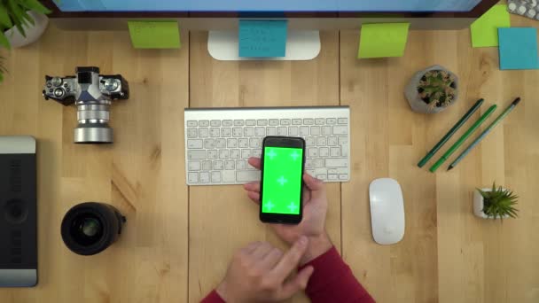 職場で緑色の画面で携帯電話を使用して人間の手のフラット レイアウト — ストック動画