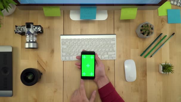 Płaskie ukształtowanie ręce człowieka przy użyciu telefonu z zielonego ekranu, w miejscu pracy — Wideo stockowe