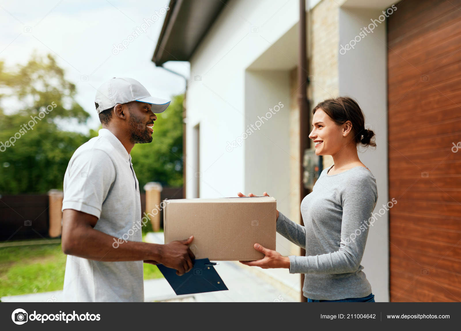 Courier Delivery Man Delivering Package To Woman At Home Stock Photo By C Puhhha 211004642
